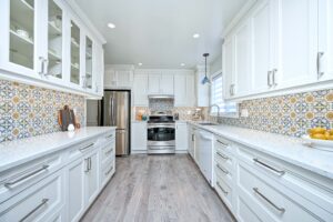 DBK Ottawa kitchen renovation showcasing white cabinetry, patterned tile backsplash, and professional craftsmanship in modern galley design